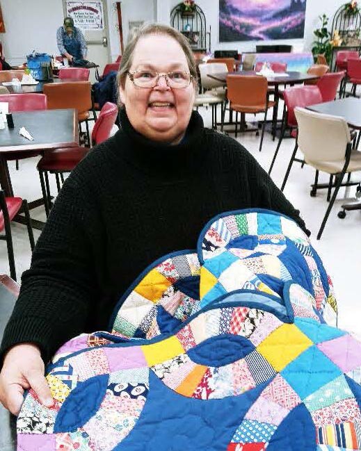 Winner Becky Church, pictured with the quilt she won. The quilt was donated by Mr. Dan Glaspy.