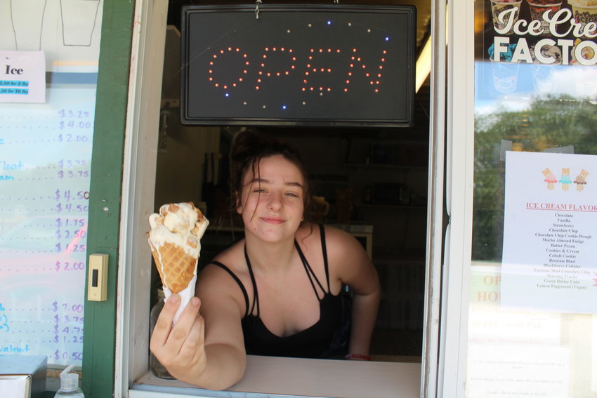 Ice Cream: Samantha Crain, a Warsaw High School student, serves a waffle cone of Gooey Butter Cake ice cream at the Grand River Resort&rsquo;s drive up window.