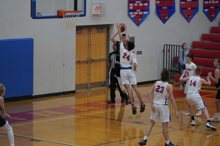 GOING FOR THE BLOCK, the Cardinals Jake Balke (24) contested a baseline jumper by Summit Christian in last Tueday's junior varsity game.  Unfortunately, the JV squad fell by a final of 53-39.  The Clinton varsity didn't fare much better as they lost  their game by a 70-54 final.