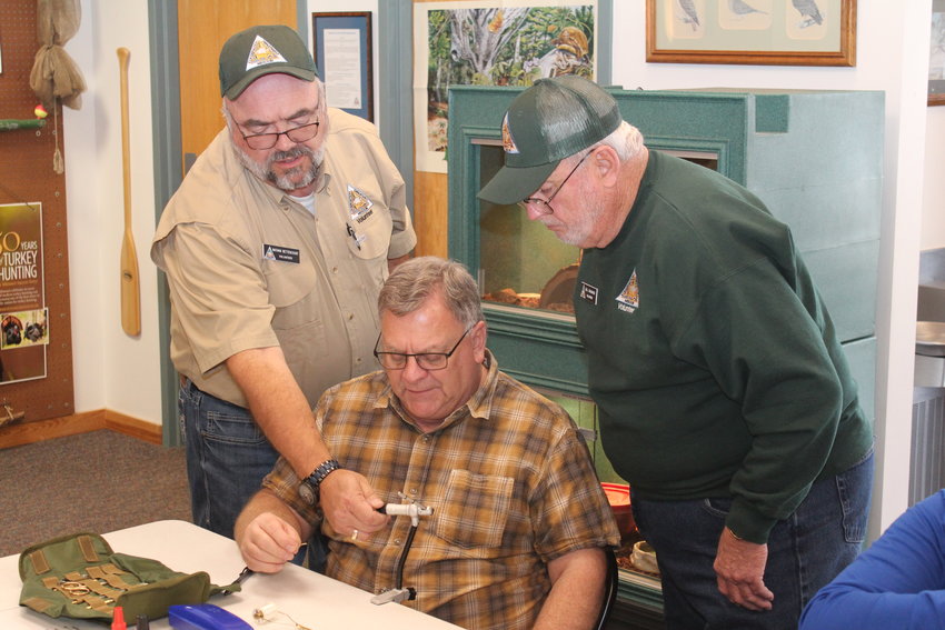 GIVING AN EDUCATION, Instructor Nathan Bettencourt and Assistant Bill Grammer helped Rob Armstrong  adjust his vise during class at Lost Valley Hatchery.