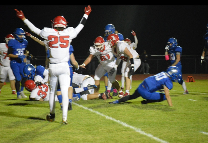 FOR THE WIN, Lincoln's Darren Roberts (25) celebrates as Ross Johnson (33) powers his way across the goal line for 1 of his 3 touchdowns in the Cardinals thrilling 38-34 victory at Cole Camp on Friday night. It was the first time the two teams had met with each state ranked.