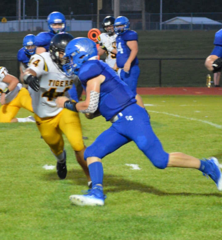 BLUEBIRD senior quarterback Ethan Shearer avoids a tackle by Wellington-Napoleon's Elijah Owens on his way to a 43 yard touchdown romp. Cole Camp won 36-7 at home on the opening night of high school football.