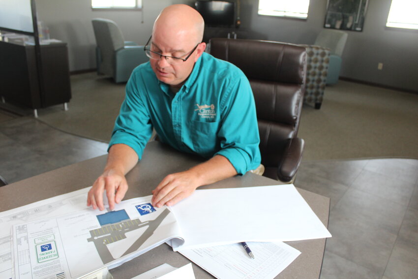 MAN WITH A PLAN, Clinton Regional Airport Manager Joel Long reviews architectural renderings for the new Terminal Building.
