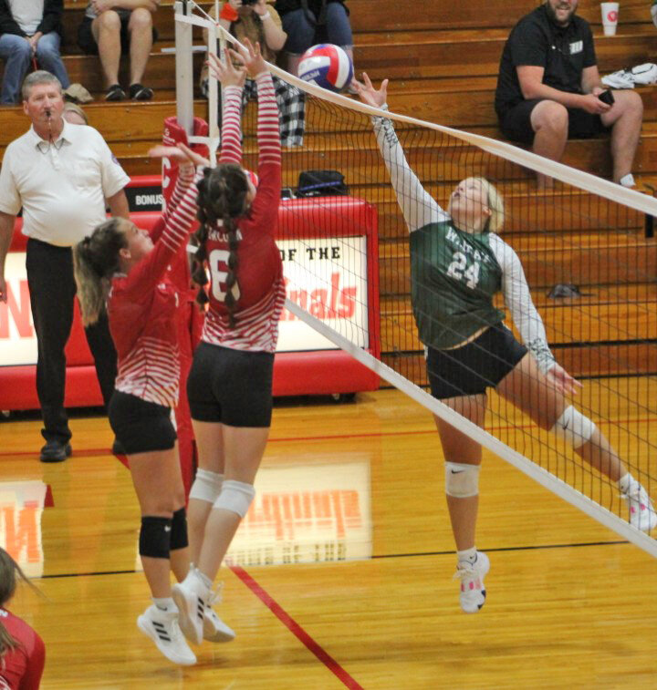 SUPREMACY AT THE NET, the Lady Cardinals' Camryn Smallwood goes up with Warsaw's Kaleby Stevenson at the net on Tuesday night in Lincoln. The Ladycats swept the match in three straight sets.