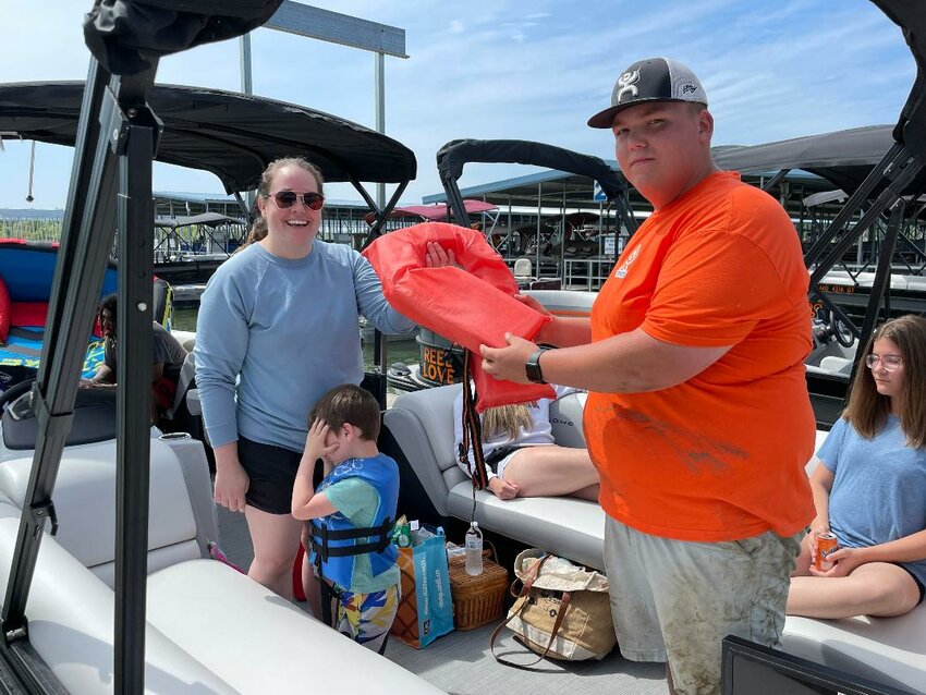 THE SUMMER SEASON ARRIVED in the twin-lakes area over the long holiday weekend with highways and waterways being jam packed. Hayden Persinger helped Alicia Hamik prepare for departure in a rental pontoon at Sterett Creek. Hamik told the Benton County Enterprise that her family drove over from Clinton to enjoy a day on Truman Lake.