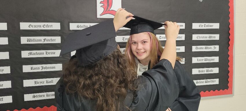 GETTING READY for the real world, LHS seniors Asia Srader and Lacey Wiggins tried on their cap and gowns on Tuesday.