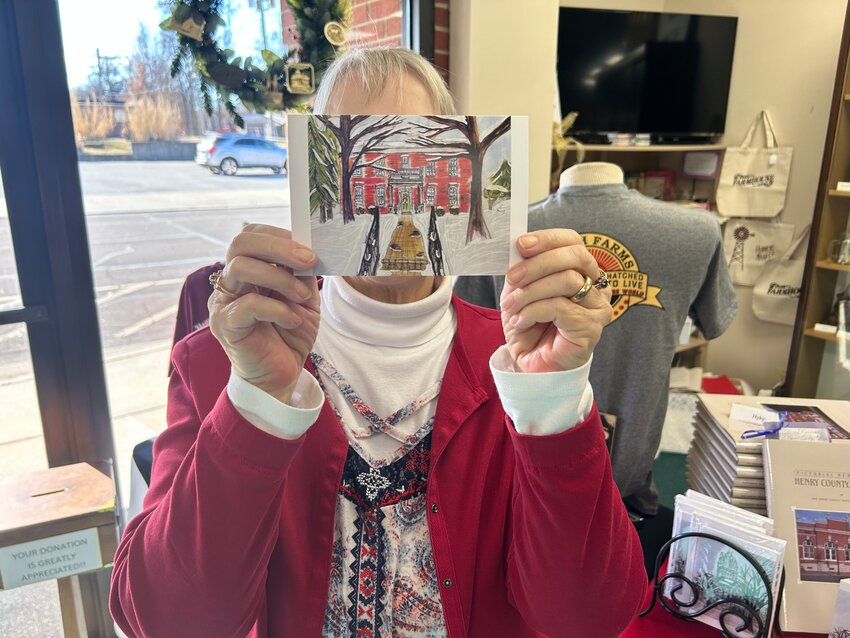 A STUNNING SET OF holiday cards depicting historic buildings in Clinton have been designed by 2007 CHS graduate Maddie Yosch. The cards are available at the Henry County Museum where Linda Hill showed one of her favorites on Tuesday.