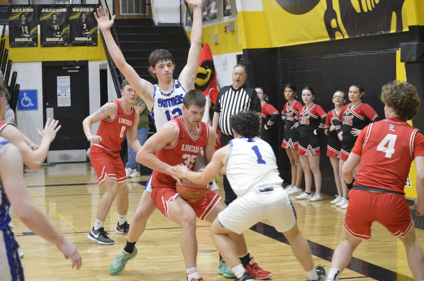 LINCOLN'S Ben Eckhoff battles for the ball at Osceola in district play on Tuesday night. The Cardinals were outscored 10-2 in the fourth, ending in a 45-36 defeat to Morrisville and a 7-18 overall record on the season.