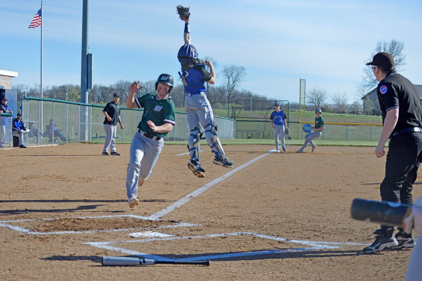 A LITTLE TOO HIGH! Cole Camp catcher Grady Strathman leaps high for an errant throw as Warsaw's Garrett Ferguson scores. In the background,  Wildcats coach Johnny Eierman reacts and Warsaw's Logan Gemes takes third as the umpire watches the play at home. Warsaw won 5-2.