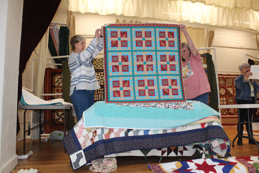 CREATIVITY AND CRAFTSMANSHIP will be on display during this weekend&rsquo;s  5th Annual Quilt Walk on the Clinton Square. Julie Nold and Patty Clark displayed a quilt made by Debbie Rodgers during the Bed Turning at the Quilters and Crafters Day in Lowry City. Cindy Moran served as the announcer.