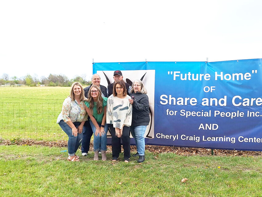 LOOKING TO THE FUTURE, the family of Cheryl Craig was invited to help put up the banner on the fence in front of the 15 acres next to the Clinton Community Center where the new buildings will be built. With the banner was Andrea Schmidt, Emily Combs, Alexa Thomsen, Becky Gregory, Phil Craig and Sandy Carroll.