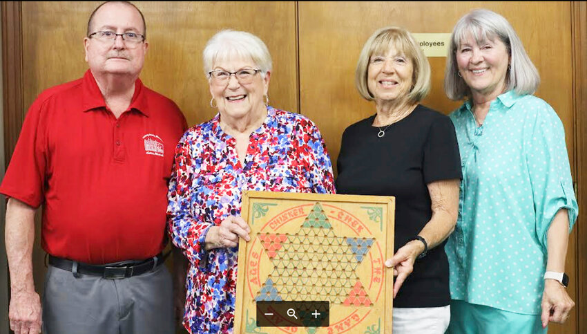 HOLDING HISTORY, Henry County Museum Board President Klein Spangler displayed a Chinker-Chek board made in Clinton. With him were board officers that included Adele Bernard, Carle Lowe and Marilynn Henry.