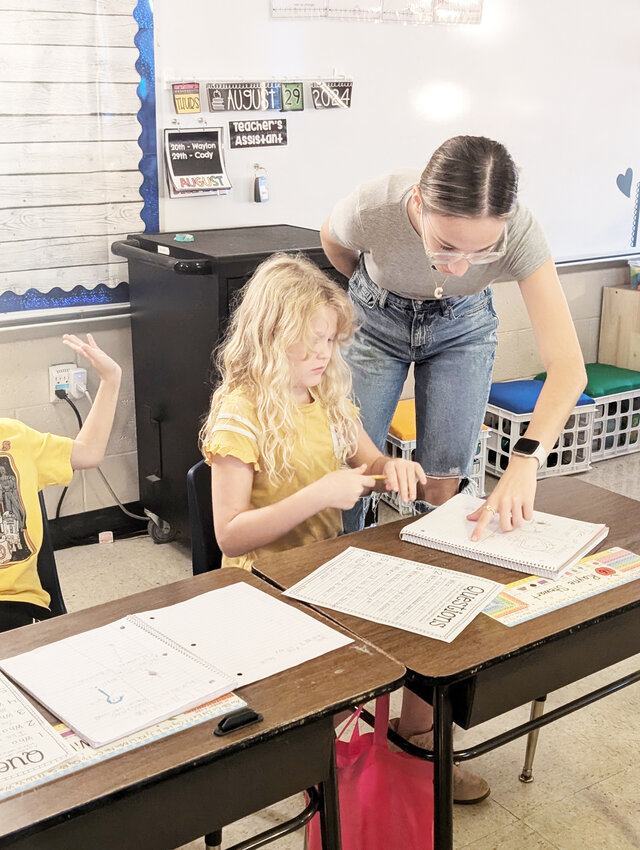 HANDS ON EXPERIENCE, CHS senior Chelsi Berry helped Rayne Stewart with an assignment. Berry spends three hours each day in Michele Bramell’s second-grade classroom.