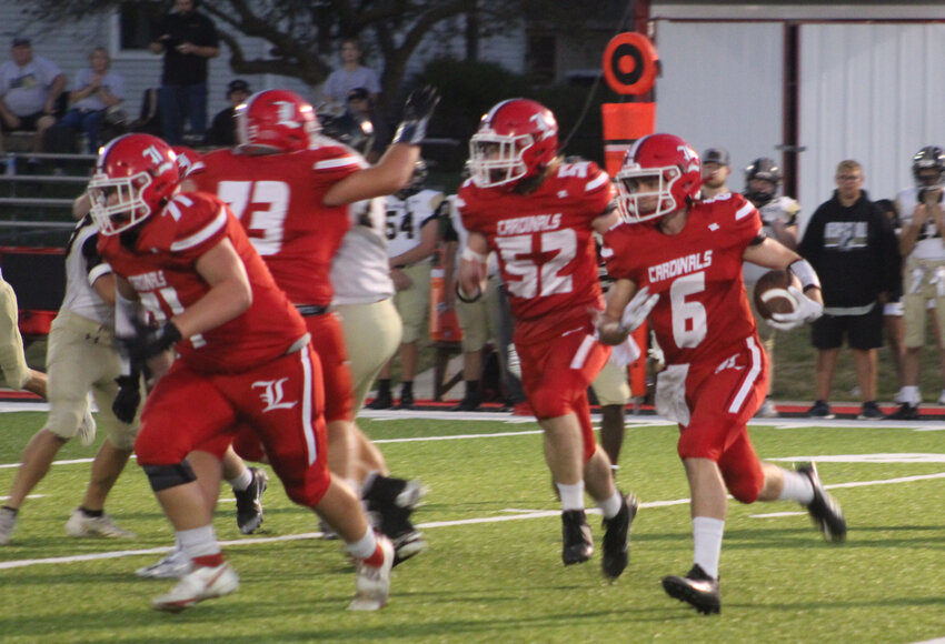 LOOKING FOR A BLOCK, Braydyn Benham (6) runs behind Ashton Wolfe (52) Matthew Cook (73) and Isacc Komm (71) for Lincoln against Adrian on Friday night in a 48-8 onslaught. Lincoln fell to 2-4.