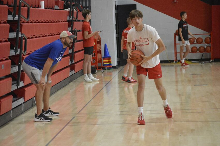 I'M WATCHING YOU! Cardinals senior Riley Sanders worked out during a recent basketball practice at Lincoln last week under the watchful eye of coach Tyler Burke.