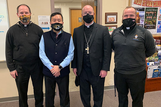 Father Daniel Merz, pastor of St. Thomas More Newman Center parish in Columbia; Dr. Mun Choi, president of the University of Missouri and chancellor of its Columbia campus; Bishop W. Shawn McKnight; and Father Paul Clark, associate pastor, pause for a photo during Dr. Choi&rsquo;s visit to the Newman Center.