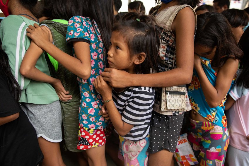 Children wait in line for food at an evacuation center in Manila, Philippines, Nov. 14, 2020, after being forced from their homes from flooding caused by Typhoon Vamco. Five tropical storms or typhoons have hit the Philippines in a three-week period, including the strongest typhoon since 2013 and the biggest floods since 2009.