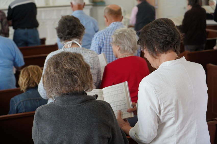 Visitors to historical St. Peter Church in Brush Creek sing a hymn together at the end of the annual spring Mass there on April 26, 2021.