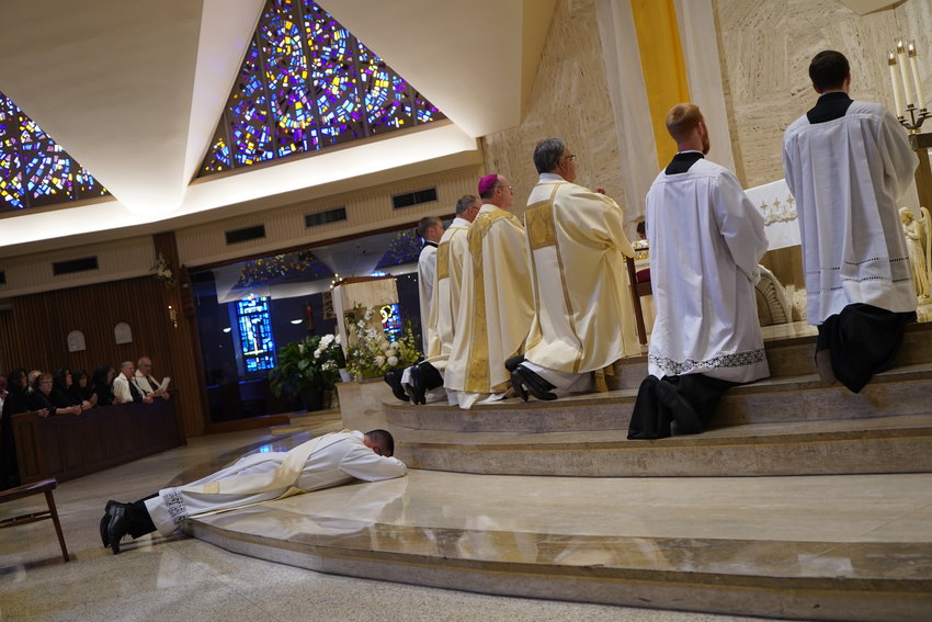 Father Derek Hooper lays prostrate before the altar in the Cathedral of St. Joseph in a gesture of obedience and total reliance on God, while the choir and congregation chant the Litany of Saints during his Ordination to the Holy Priesthood on June. 5.