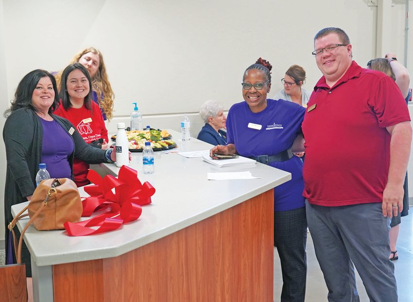 Several members of the Catholic Charities of Central and Northern Missouri (CCCNMO) staff gather around the reception desk inside the new Catholic Charities center in Jefferson City during an Oct. 16 open house following the blessing and dedication of the nearly completed building. It will serve as a hub of charity and mercy in the Capital Area and command center for Catholic Charities activities throughout the Jefferson City diocese.