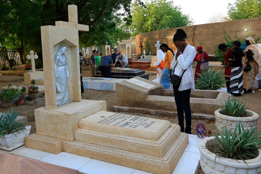 A family prays next to a relative&rsquo;s grave in a cemetery during All Souls&rsquo; Day in Khartoum, Sudan, in this Nov. 11, 2014, file photo. With the continuing pandemic, the Vatican has again extended throughout all of November the opportunity to receive a plenary indulgence for visiting a cemetery to pray for the dead.