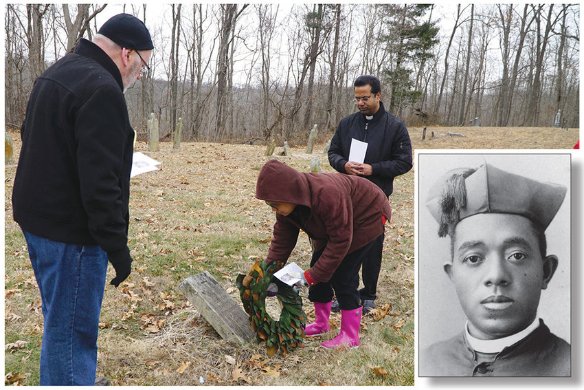 Janice Mulligan lays a wreath of magnolia leaves on the grave of Matilda (Hurd) Chisley as Father Ronald Knott, left, and Father George Illikkal look on. At right is an undated photo of Venerable Father Augustus Tolton.