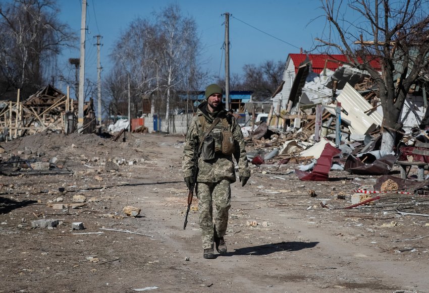 A Ukrainian service member walks past destroyed homes after they were hit during a Russian military strike in Kyiv, Ukraine, March 21, 2022.