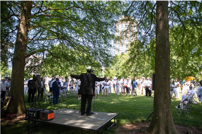Participants in a June 18 prayer service and Maafa procession to the grounds of the Gateway Arch in St. Louis listen to stories of individuals who were enslaved by people in the Church.