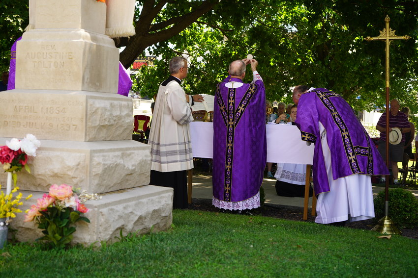 Bishop Thomas J. Paprocki of Springfield, Illinois, elevates the Most Blessed Sacrament during Mass at the burial place of Venerable Father Augustus Tolton in St. Peter Cemetery in Quincy, Illinois, on July 9, the 125th anniversary of Fr. Tolton&rsquo;s death.