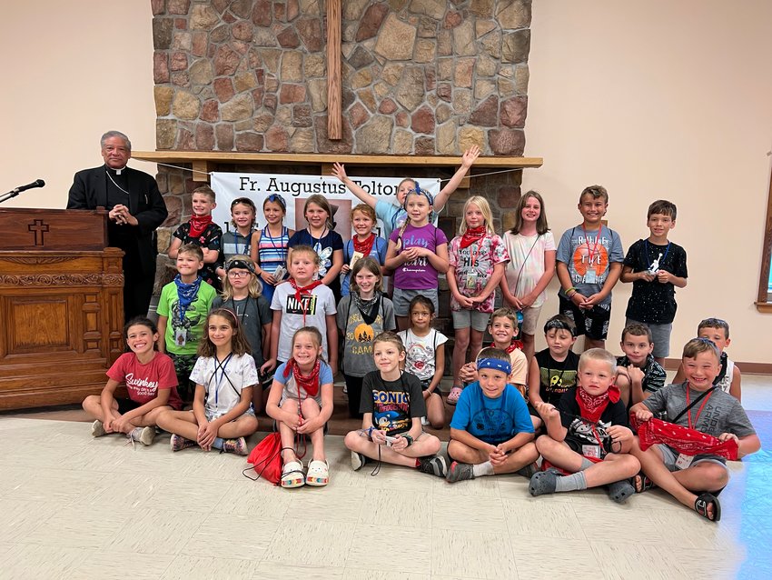 Auxiliary Bishop Joseph N. Perry of Chicago, postulator for the sainthood cause of Venerable Father Augustus Tolton, gathers for a group photo with children during Camp Tolton at Camp Jo&rsquo;Ota in Clarence.