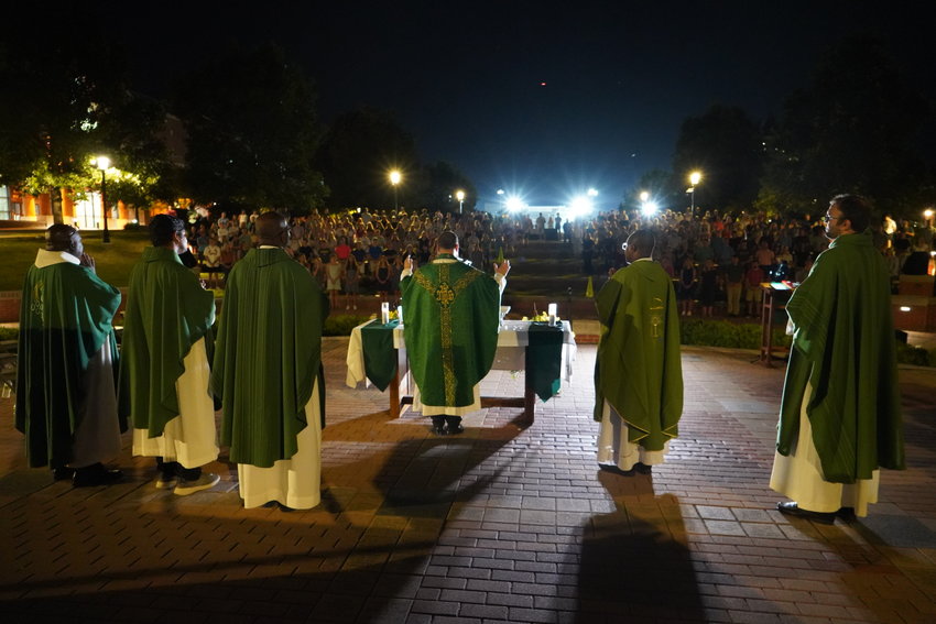 Father Paul Clark and concelebrating priests gather around the altar for the Consecration during this year&rsquo;s Mass in the Quad on the campus of the University of Missouri in Columbia.