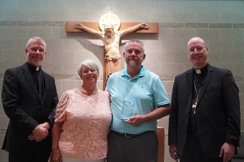 Father Jeremy Secrist, pastor of St. Peter Parish in Jefferson City, parishioners Carol and Dean Dutoi, and Bishop W. Shawn McKnight gather before the altar in the chapel of the Alphonse J. Schwartze Memorial Catholic Center in Jefferson City Aug. 30, after Bishop McKnight presented Mr. Dutoi the Missouri Catholic Conference&rsquo;s 2022 Citizen Recognition Award for the Jefferson City diocese. Mr. Dutoi served for over a decade as president of St. Peter Parish&rsquo;s conference of the St. Vincent de Paul Society.