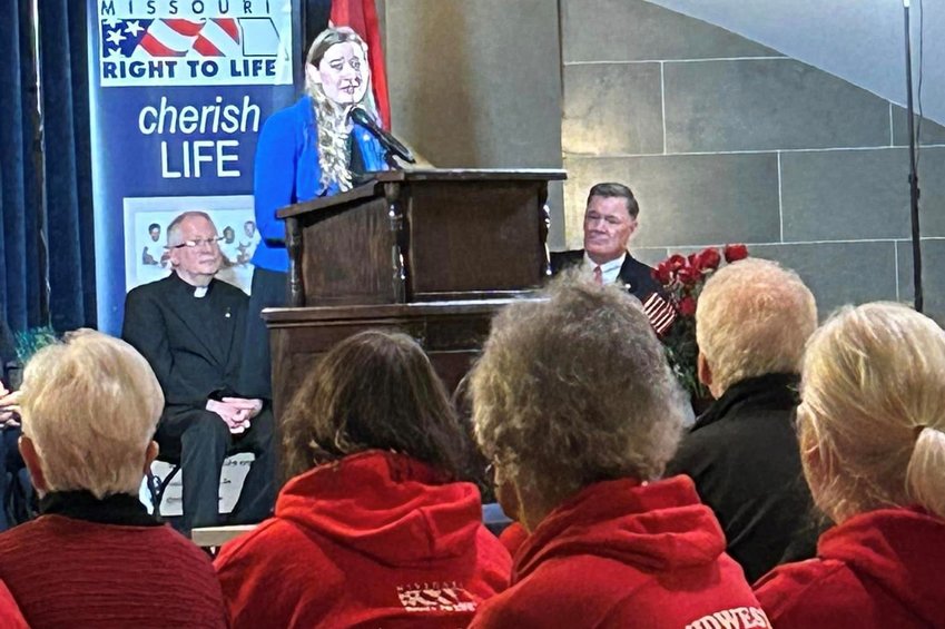 Monsignor David Cox, pastor of St. Stanislaus Parish in Wardsville and St. Margaret of Antioch Parish in Osage Bend (left, seated) listens to a speaker during Missouri Right to Life&rsquo;s Pro-Life Action Day in the State Capitol.