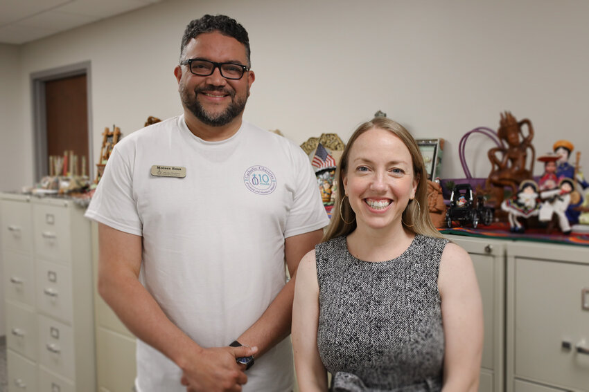 Moises Sosa (left) and Marissa Flores Madden (right), standing with many tokens of thanks gifted to the Family Immigration Services program over the years, are DOJ Accredited Representatives providing immigration legal services for clients at Catholic Charities of Central and Northern Missouri.