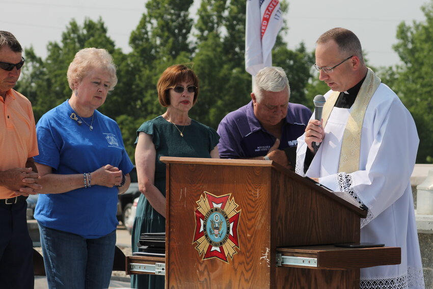 Father Jason Doke, pastor of St. Martin Parish in St. Martins, proclaims a reading from Scripture during the dedication of the Veterans and First Responders Memorial at Veterans of Foreign Wars Post 1003 in St. Martins.