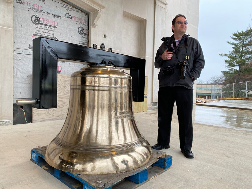 Jay Nies, editor of The Catholic Missourian, stands next to one of the new bells for the Cathedral of St. Joseph in Jefferson City on March 31, 2023, the day Bishop W. Shawn McKnight blessed them.