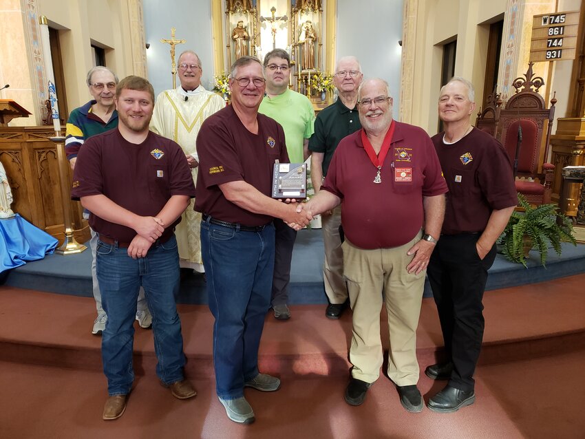 Richard Wieberg (right), District Deputy 20 of the Knights of Columbus Missouri State Council, presents the Star Council Award to Hermann Council Grand Knight Tom Bruckerhoff at a recent Mass at St. George Church in Hermann. Father Philip Niekamp (second row), pastor of St. George parish and council chaplain, is with other members of Council 1914.