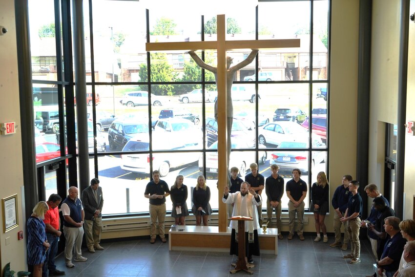 Father Paul Clark, chaplain of Helias Catholic High School in Jefferson City, blesses and rededicates the renewed &ldquo;Crucifix Entrance&rdquo; to the school during a Sept. 7 ceremony.