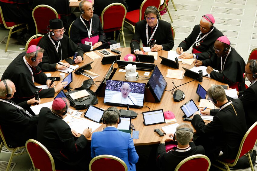 Pope Francis is seen on a monitor as he speaks to participants in the assembly of the Synod of Bishops during their first working session in the Paul VI Audience Hall at the Vatican Oct 4.