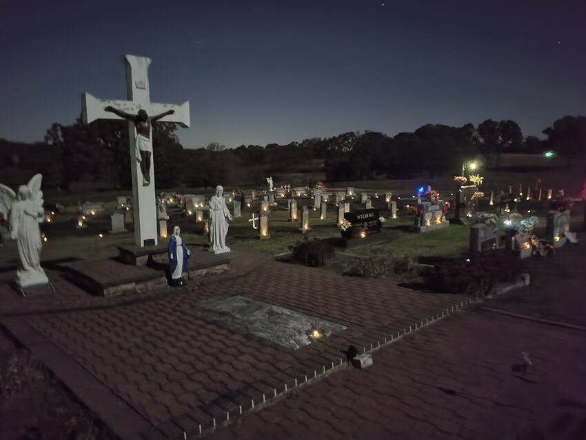 Moonlight and hundreds of electric tea lights illuminate St. Anthony Cemetery in St. Anthony near midnight on Nov. 1, the Solemnity of All Souls. Eighth- through 12th-grade CCD students placed the lights on headstones throughout the cemetery to remind people to pray for their deceased loved ones and all the faithful departed who are preparing to share the fullness of their Master&rsquo;s joy.