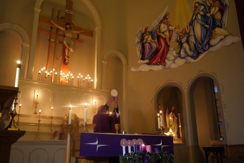 Father Anthony Rinaldo, pastor of Immaculate Conception Parish in Loose Creek and St. Louis of France Parish in Bonnots Mill, elevates the Most Blessed Sacrament during a Candlelight Mass on the evening of the First Sunday of Advent in Immaculate Conception Church in Loose Creek.