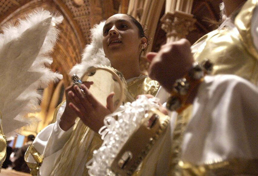 Monica Reyes performs with a musical group during a posadas celebration at Holy Name Cathedral in Chicago in this file photo. Posadas, a traditional Christmas festivity in many Hispanic cultures, are marked by a candlelight procession.