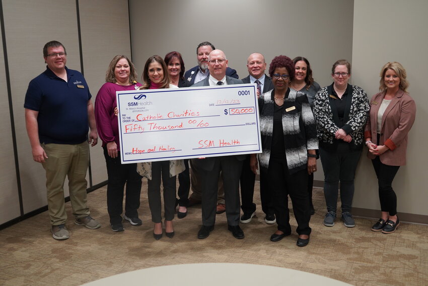 Representatives of Catholic Charities of Central and Northern Missouri and SSM Health St. Mary&rsquo;s Hospital-Jefferson City take part in a Dec. 12 ceremony marking SSM Health&rsquo;s $50,000 investment in the Hope and Healing Food Bag program.