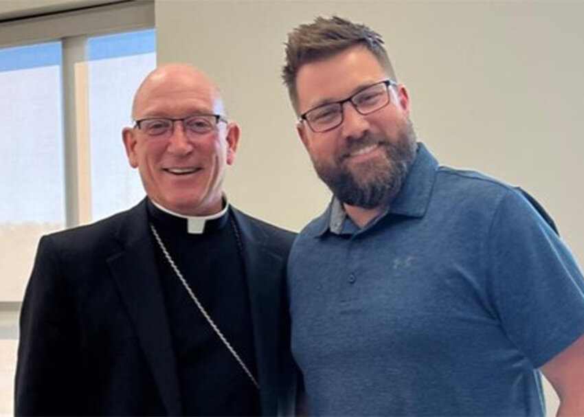Bishop Edward M. Rice of the Diocese of Springfield-Cape Girardeau, Missouri, presents the diocese&rsquo;s Teacher of the Year award to Jefferson City native Cam Branson at a faculty in-service event in Joplin.