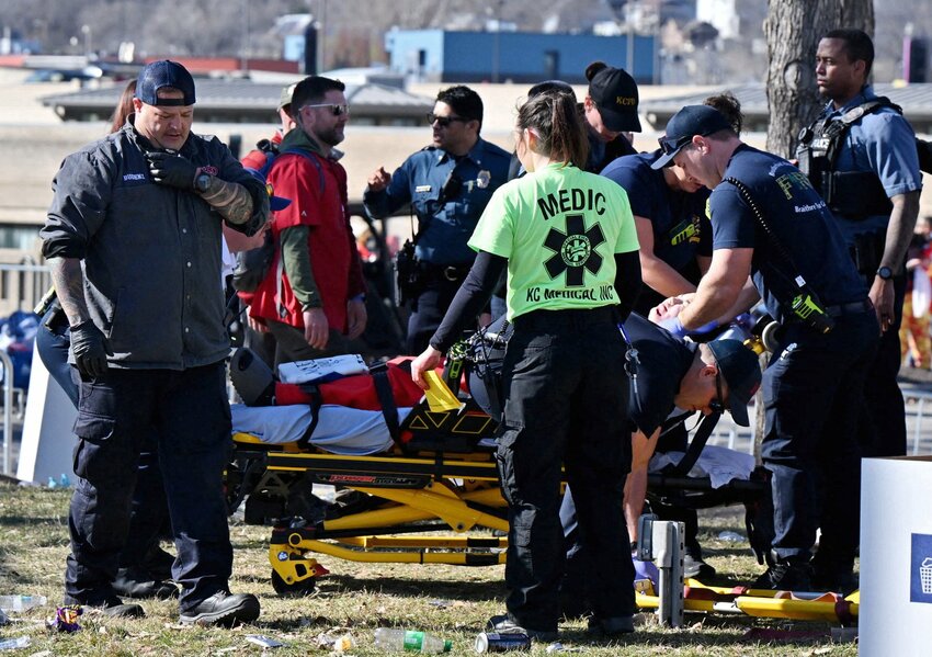 Medical personnel attend to an injured fan after gun shots were fired in Kansas City, Mo., after the celebration of the Kansas City Chiefs winning Super Bowl LVIII. The shooting at the end of the parade left one dead and at least 15 injured, while sending terrified fans running for cover.