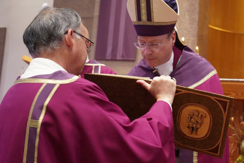 Bishop W. Shawn McKnight signs the Book of the Elect during the Rite of Election and Call to Continuing Conversion in this 2022 file photo.