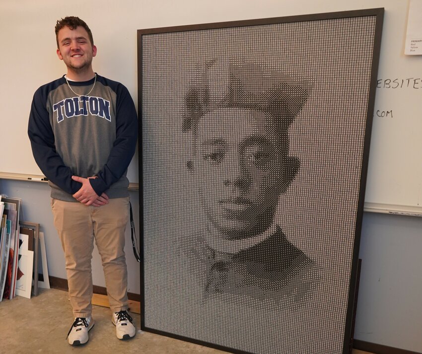 Nate Pfenenger, a senior at Fr. Tolton Regional Catholic High School in Columbia, displays the mosaic portrait of Venerable Father Augustus Tolton that he created out of 20,400 black dice. Fr. Tolton (1854-97) was born into an enslaved family in northeastern Missouri, escaped to Illinois with his family and overcame enormous obstacles to become the Roman Catholic Church&rsquo;s first recognizably Black priest in the United States.