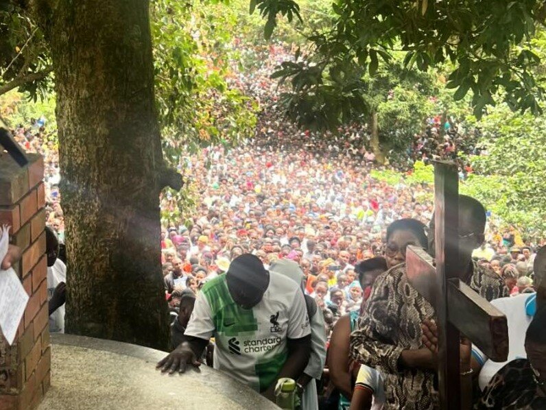 About 60,000 people join Father Joseph Luzindana, a priest of the Archdiocese of Kampala, Uganda, who is serving on mission in the Jefferson City diocese, in meditating on the Stations of the Cross on a mountain leading up to a Marian shrine on Good Friday during a recent visit to his homeland with a group from this diocese.