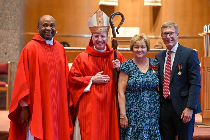 Cheryl and Michael Kelly stand with Father Roberto Ike, pastor of Our Lady of Lourdes Parish in Columbia, and Bishop W. Shawn McKnight on May 18, the day the bishop presented the couple with the Knight of Pope St. Sylvester and Dame of Pope St. Sylvester award at Mass in Our Lady of Lourdes Church in Columbia.