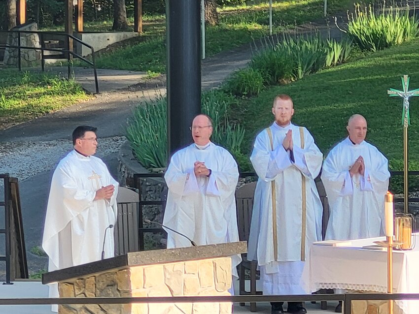 Bishop W. Shawn McKnight joins Father John Schmitz, Rev. Mr. Christopher Hoffmann and Father Louis Nelen in the outdoor sanctuary of the National Shrine of Mary, Mother of the Church, in Laurie during a Mass to celebrate the feast of Mary, Mother of the Church, on May 20.